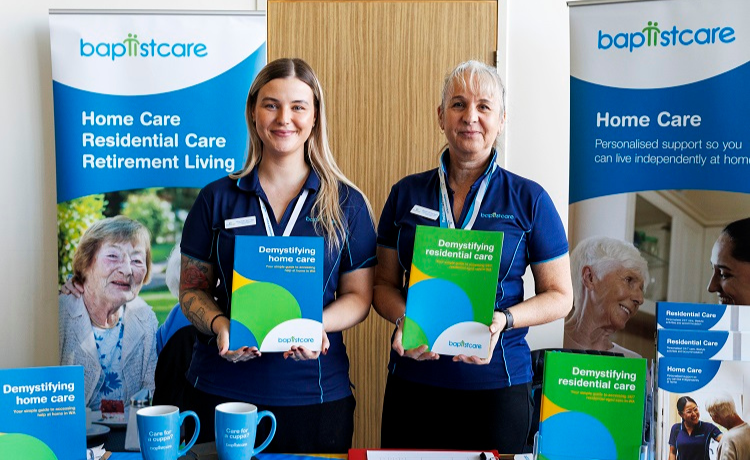 BaptistCare staff standing at a stall holding leaflets