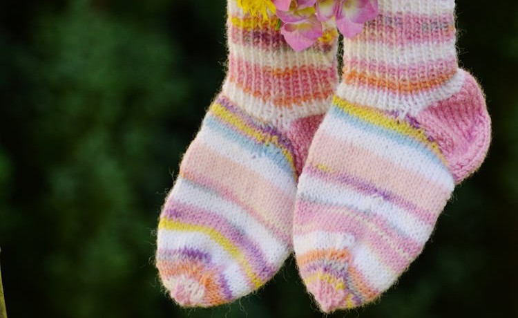 Pair of knitted socks on green background