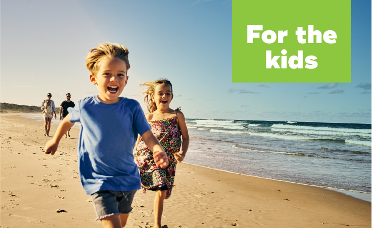 Young child running down the beach and smiling.