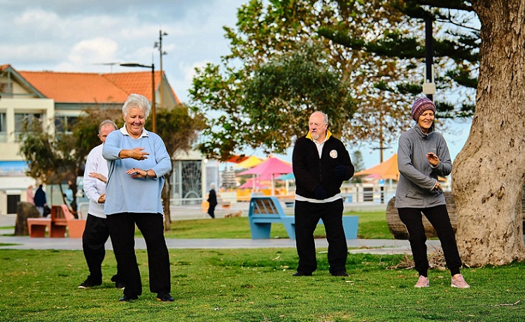 people outside in the open air doing tai chi