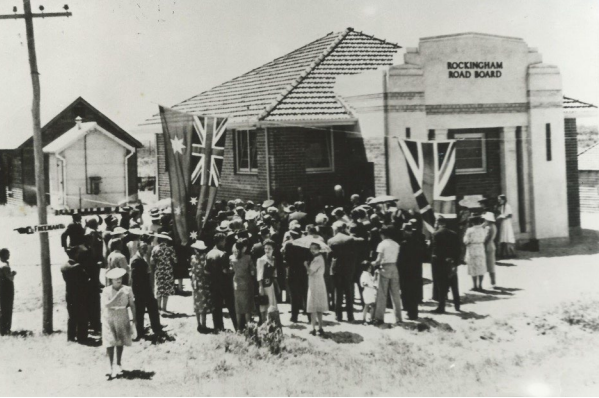 Historic black and white photo of a people at an event outside the Rockingham Road Board.