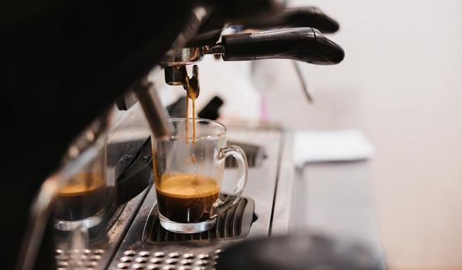 Coffee dripping into a cup from a coffee machine.