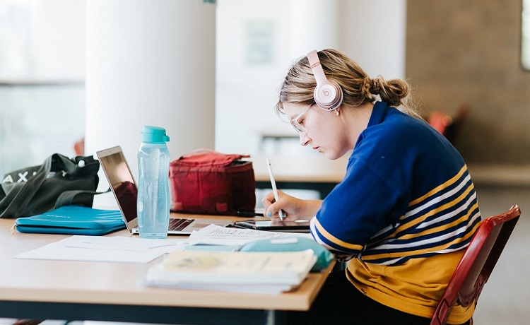 Young person studying at the library.