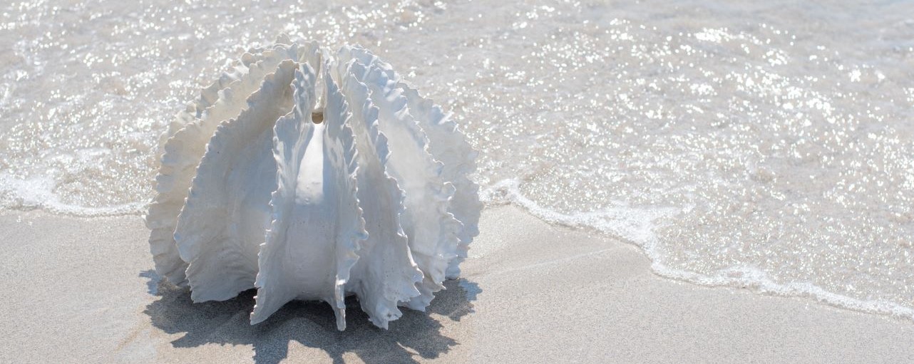 Close-up of a bright yellow sculpture resembling a pincushion protea, made from recycled street sweeper brushes, fan blades, and steel tubing.