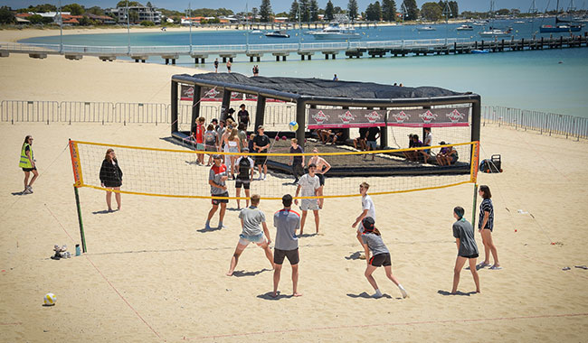 Young people playing beach volleyball at Rockingham Beach.