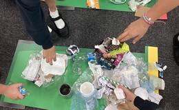 a group of people standing around a table with trash