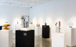 a room with white pedestals and sculptures