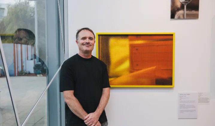a man standing in front of a painting
