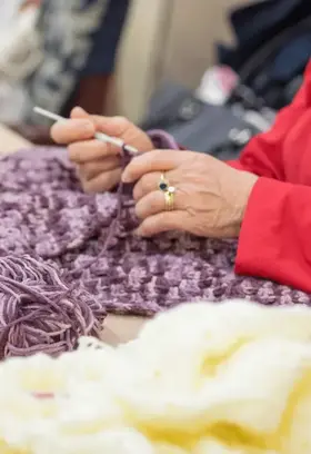 a person knitting with a crochet hook