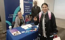 a group of people standing next to a table