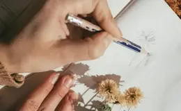 a person drawing on a book