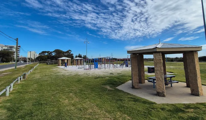 a playground with a structure and a picnic table