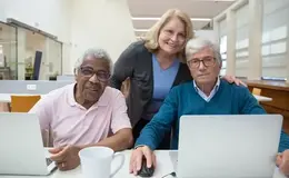 a group of people sitting at a table with a computer