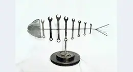 a metal fish sculpture with wrenches