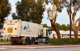 a garbage truck parked on the side of a road