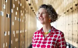 a woman smiling in a red and white polka dot shirt