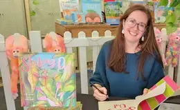 a woman sitting at a table with a book