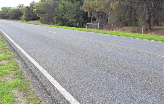 a road with grass and trees