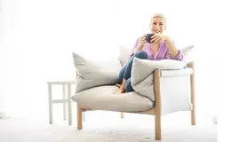 a woman sitting in a chair holding a cup
