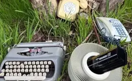 a typewriter and telephones in the grass