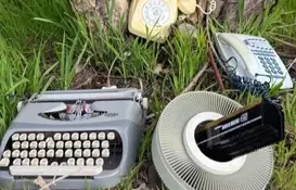 a typewriter and telephones in the grass