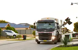 Waste truck collecting red bin