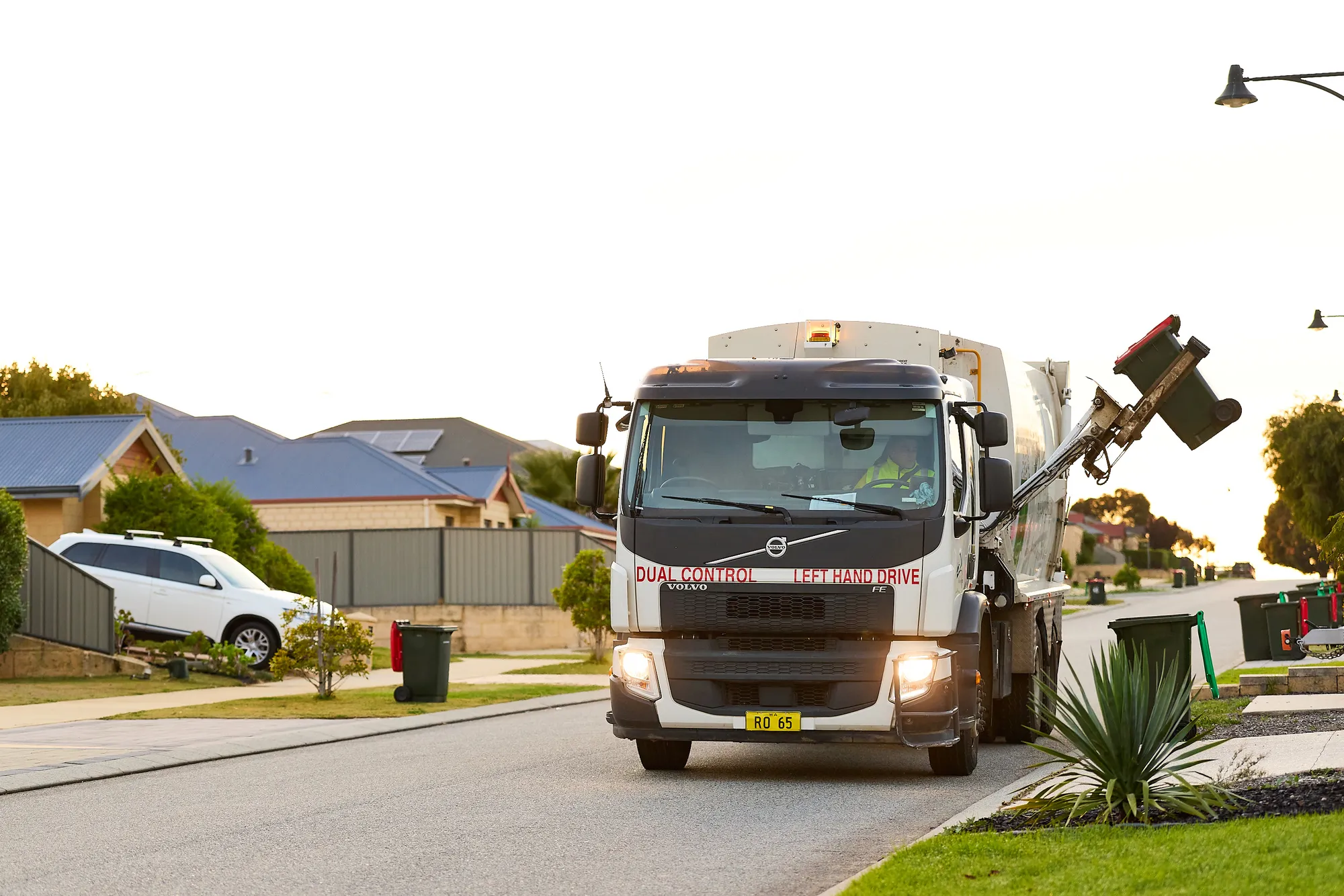 Waste truck collecting red bin