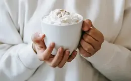 a person holding a cup of hot chocolate
