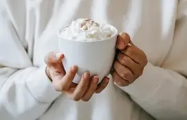 a person holding a cup of hot chocolate