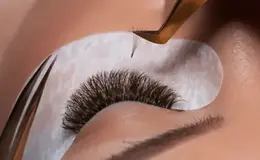 a person using tweezers to remove a long lashes