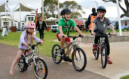 Three children sitting on their bikes.
