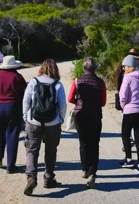 a group of people walking on a dirt road