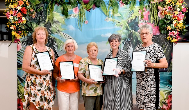 a group of women holding certificates