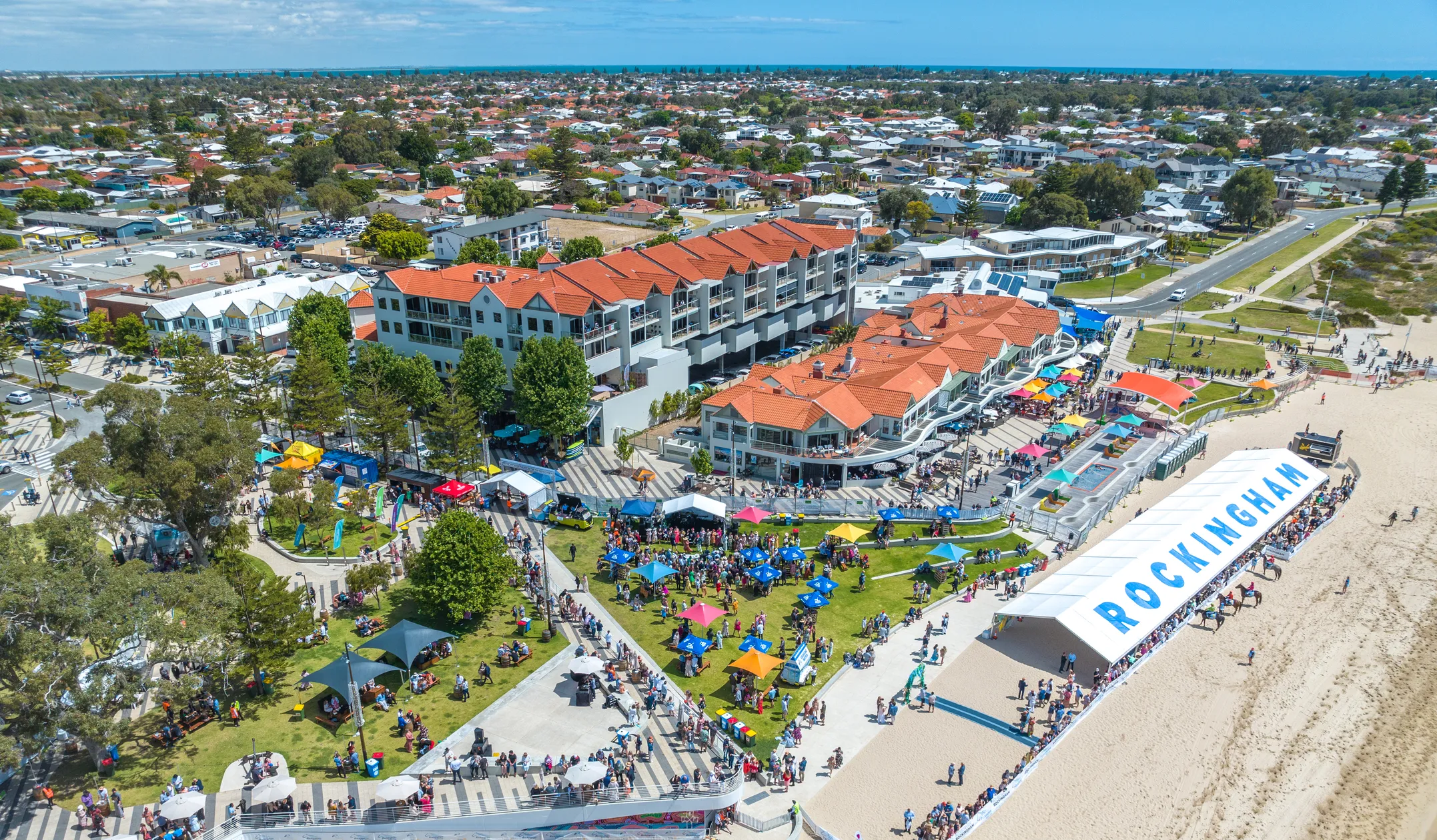 aerial view of a beach with many people and tents