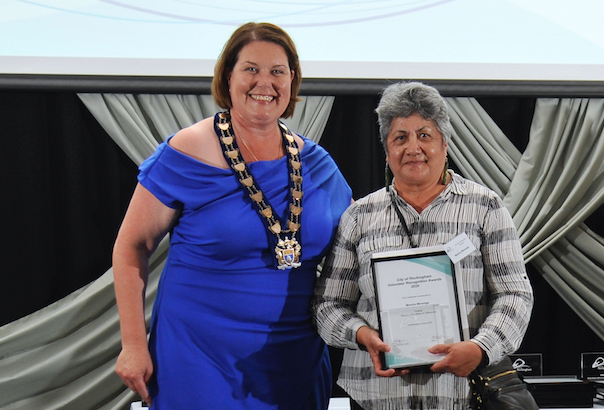 a woman holding a certificate and smiling