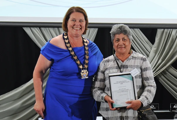 a woman holding a certificate and smiling