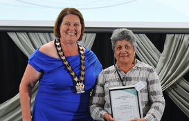 a woman holding a certificate and smiling