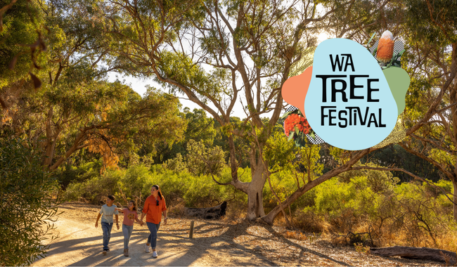 a group of people walking on a dirt path with trees and a logo