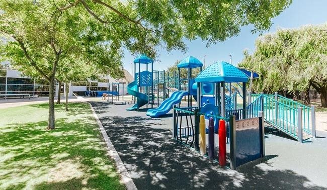 a playground with blue slides and trees