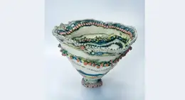 a ceramic bowl with colorful beads