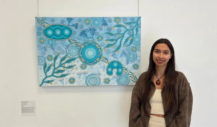 a woman standing in front of a painting