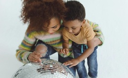 a woman and a child looking at a disco ball