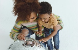 a woman and a child looking at a disco ball