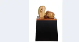 a wooden sculpture on a black stand