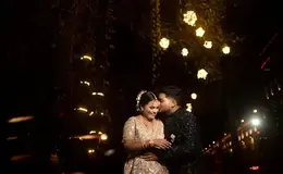 a man and woman standing under lights