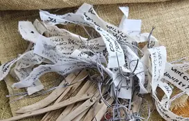 a group of wooden sticks with tags on a cloth