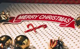 a red and white banner with a red ribbon and candy canes