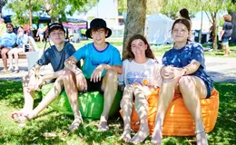 4 young people, 2 males, 2 females sat on bean bags under a tree