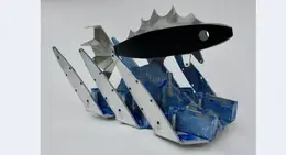 a metal fish sculpture with blue and silver parts
