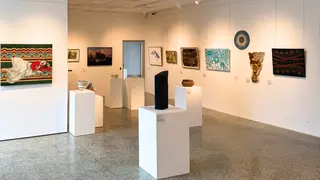 a room with white pedestals and art on the wall